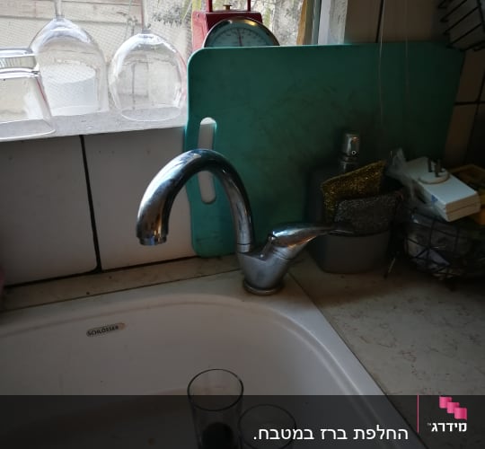 ברז מטבח עם כיור וכוסות על השיש